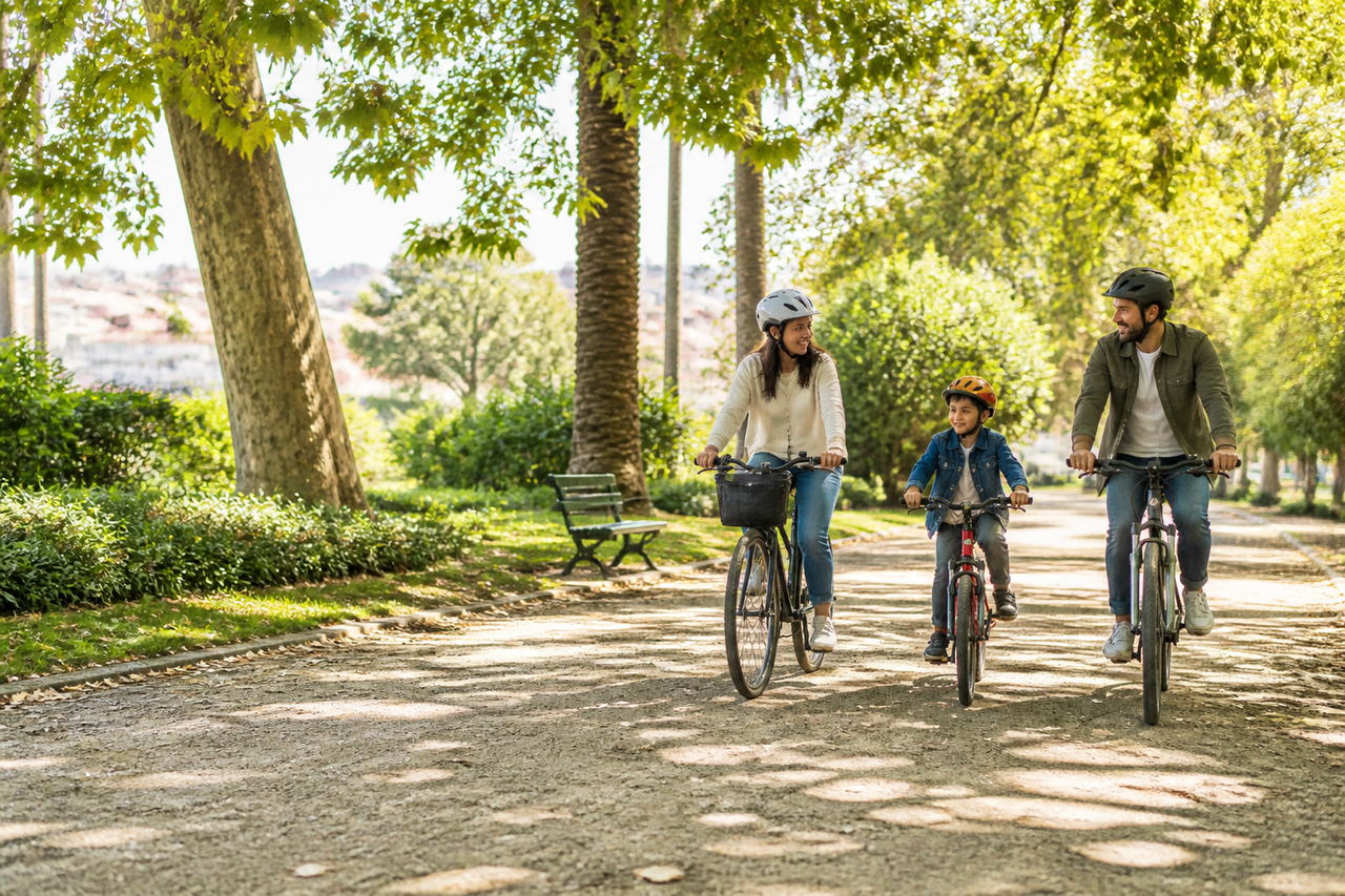 Família a andar de bicicleta num parque de Lisboa